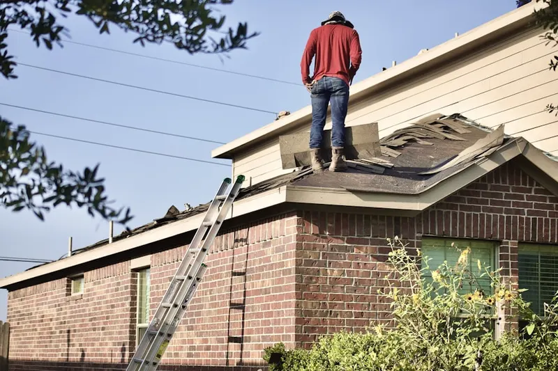 Professional roofer working on a residential roof in College-Glen